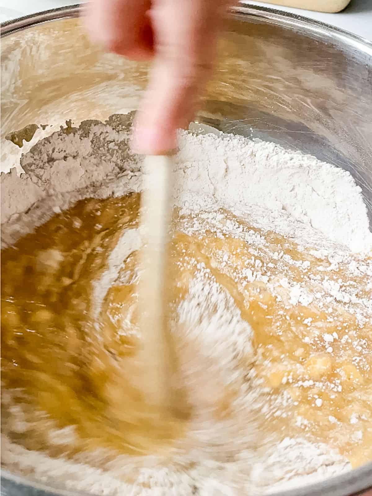 stirring wet ingredients into the dry with a wooden spoon