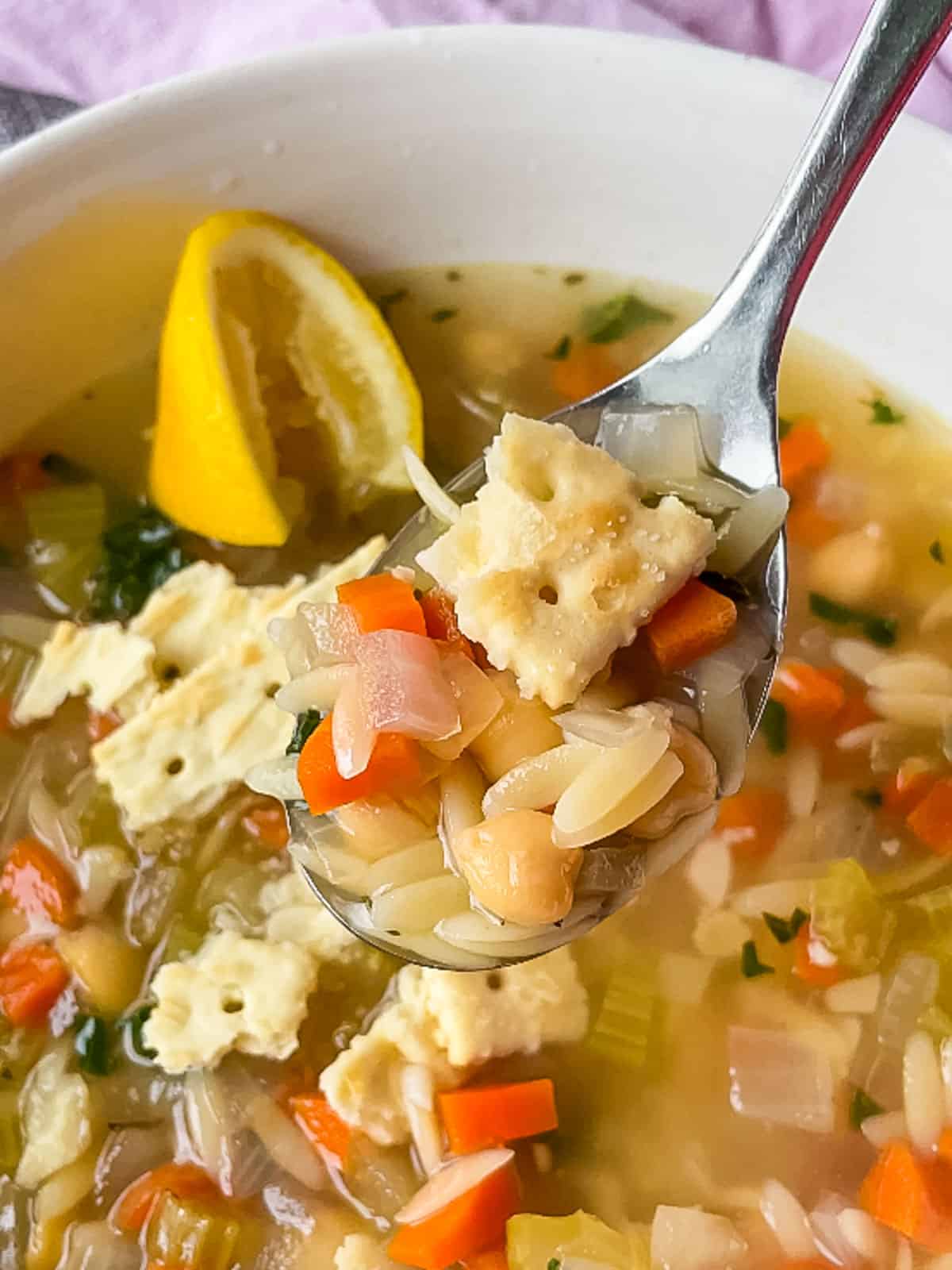 spoonful of soup with saltine crackers on top