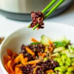 purple sushi multigrain rice in green chopsticks over bowl