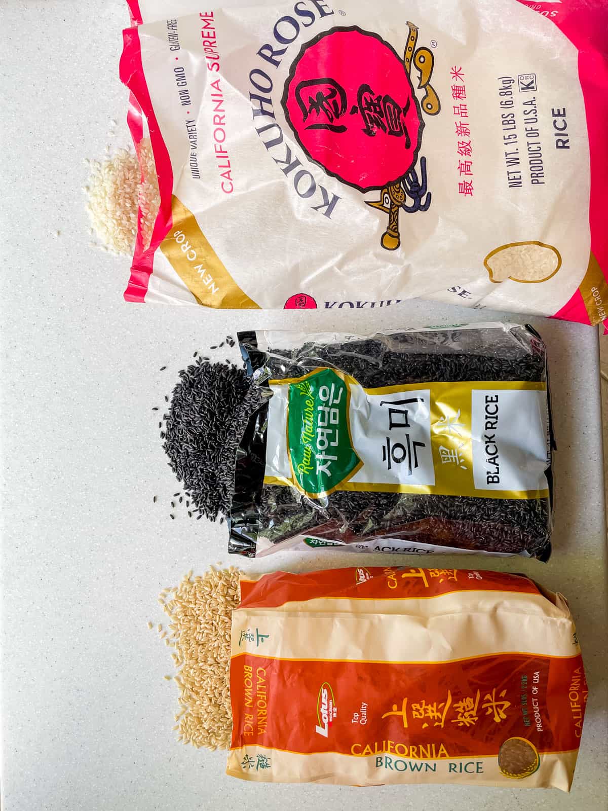 three bags of rice (white sushi, black and brown rice)