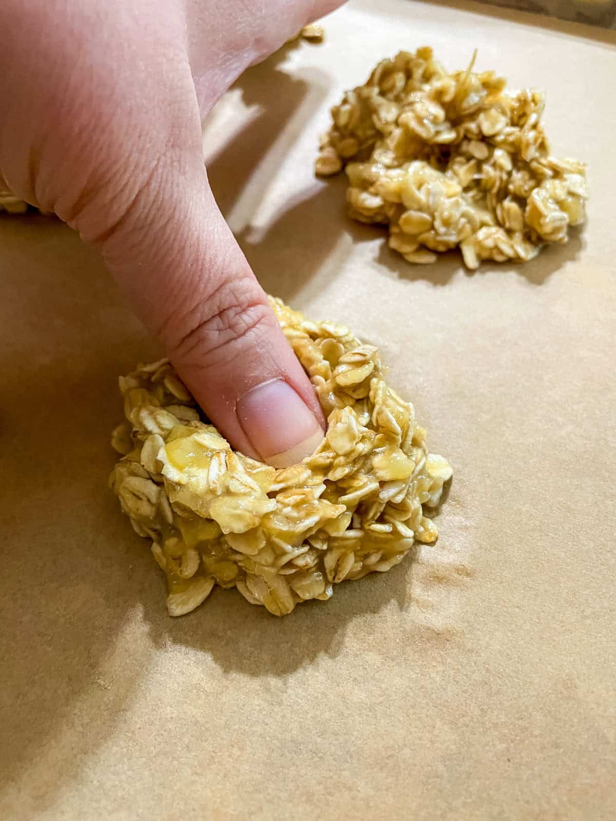 pressing a thumb into the center of a cookie to make a well