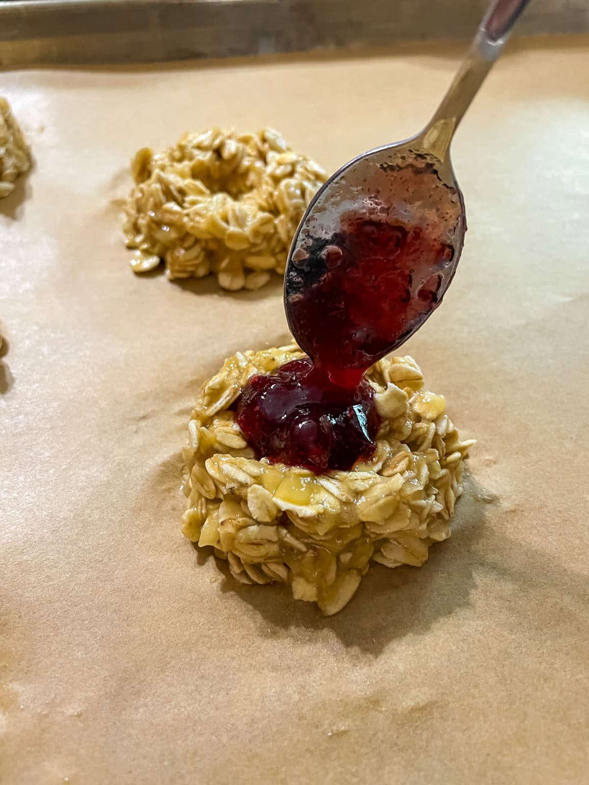 spooning fruit jam into the center well of the cookie