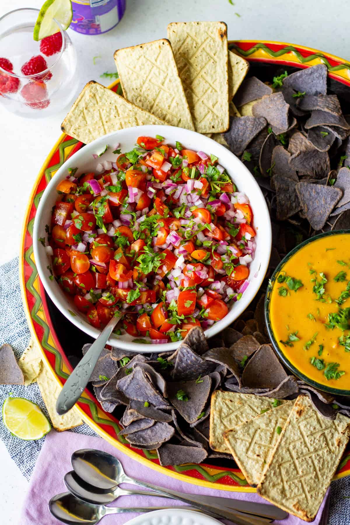 Big platter of pico de gallo and vegan rotel dip with blue corn chips and yellow corn chips