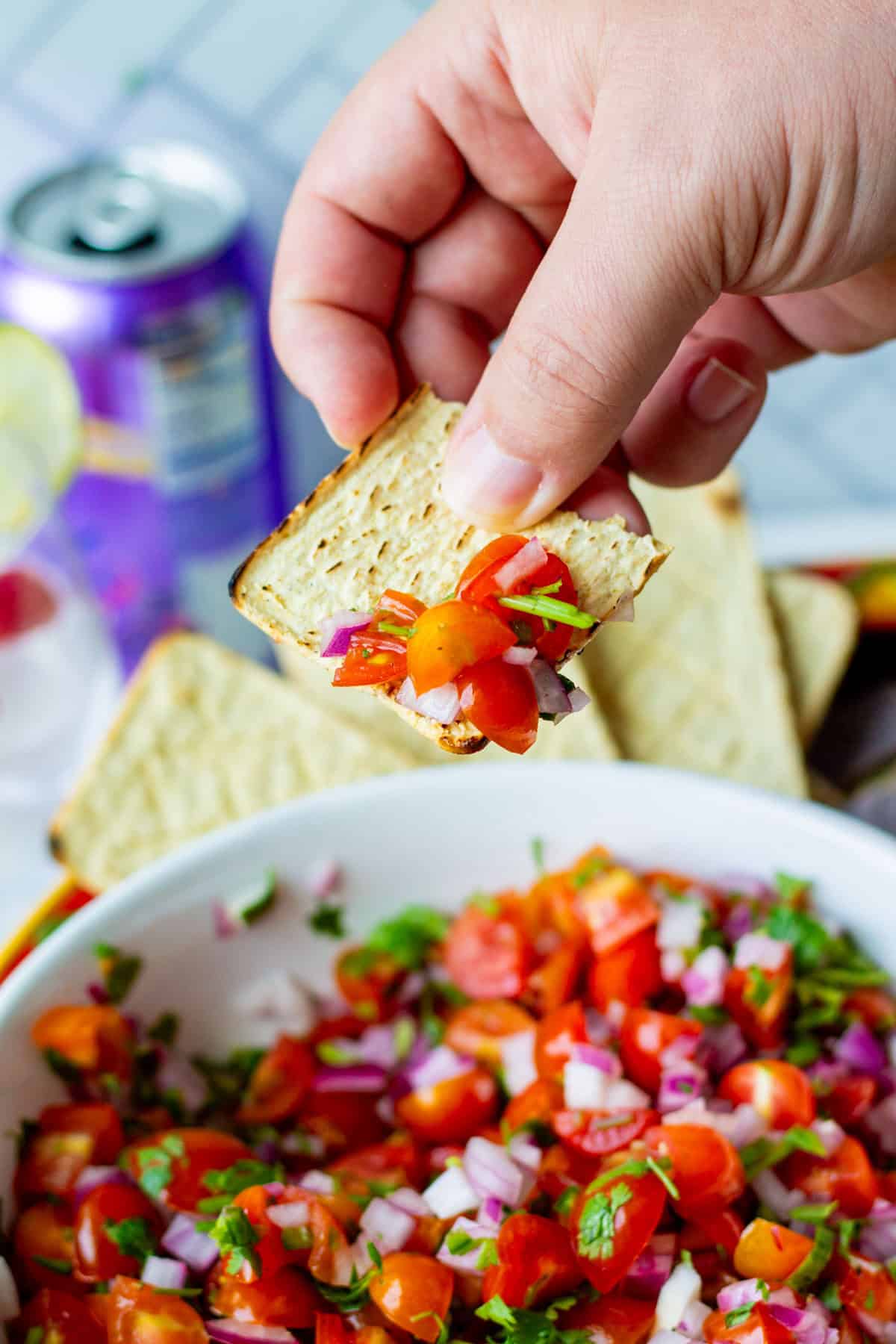 Dipping a chip into bowl of pico de gallo