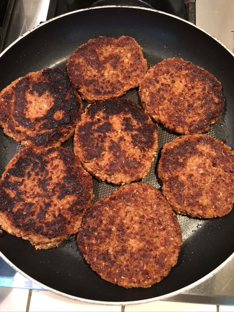 7 bean burgers being pan-seared in large skillet