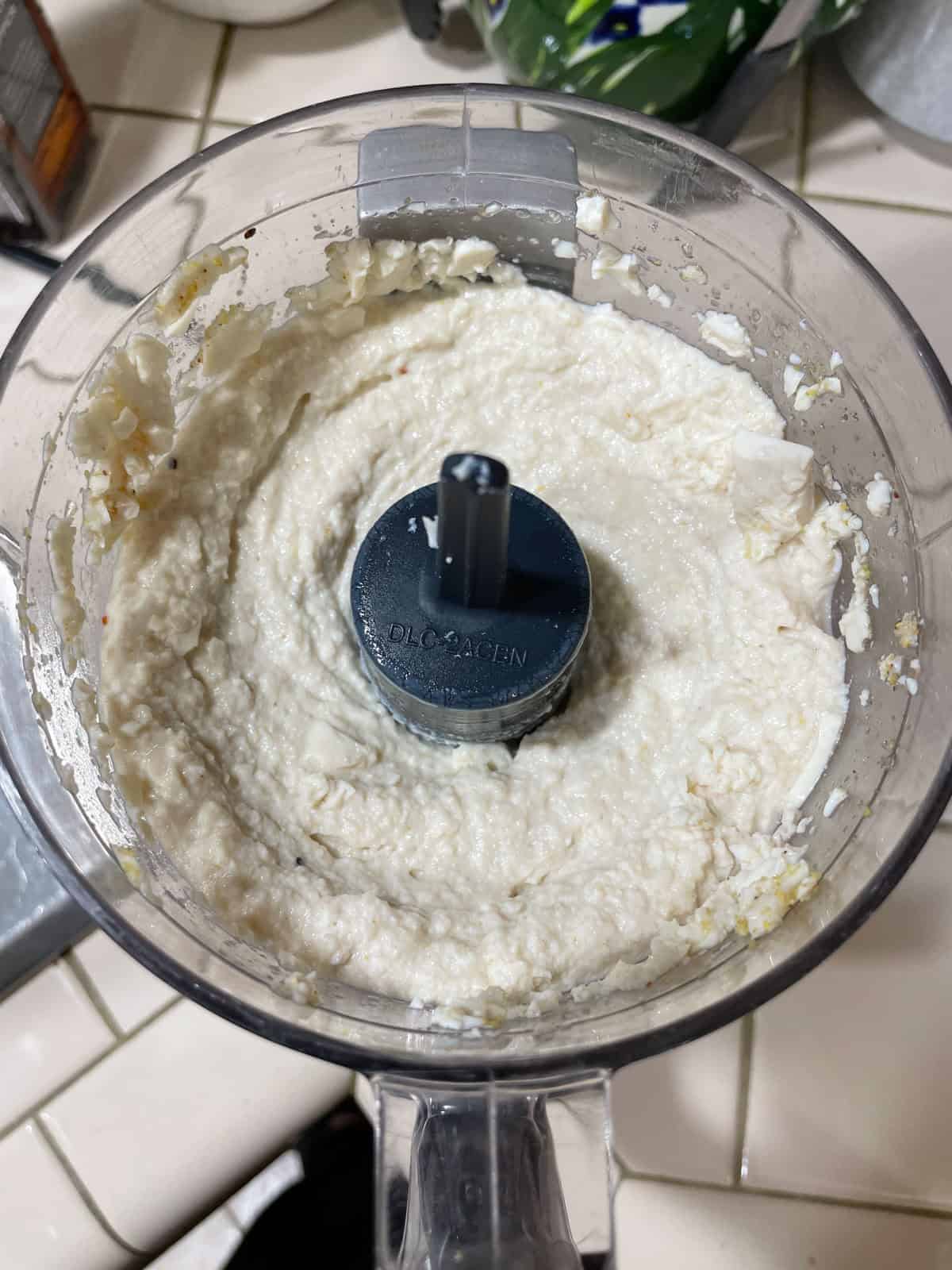 Lumpy halfway-blended silken tofu mayo in mini food processor. Needs to be processed more.