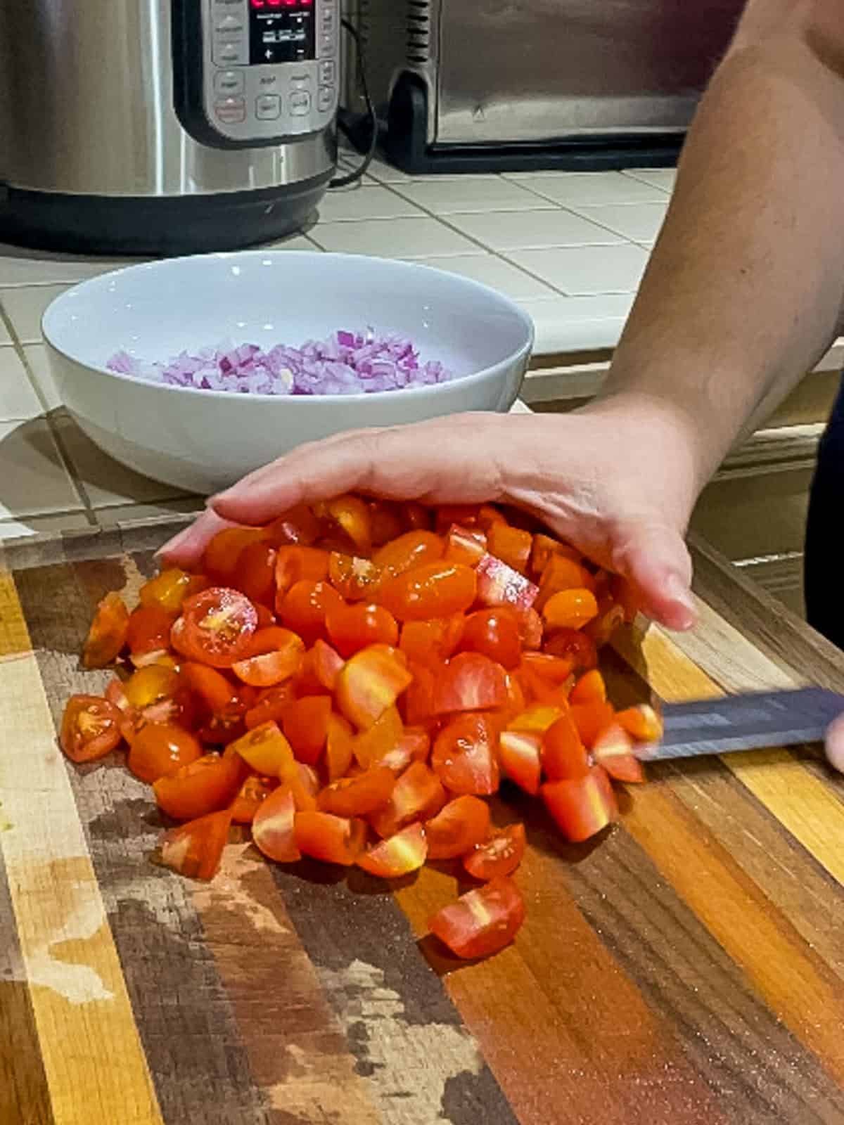 Quartering cherry tomatoes on chopping board