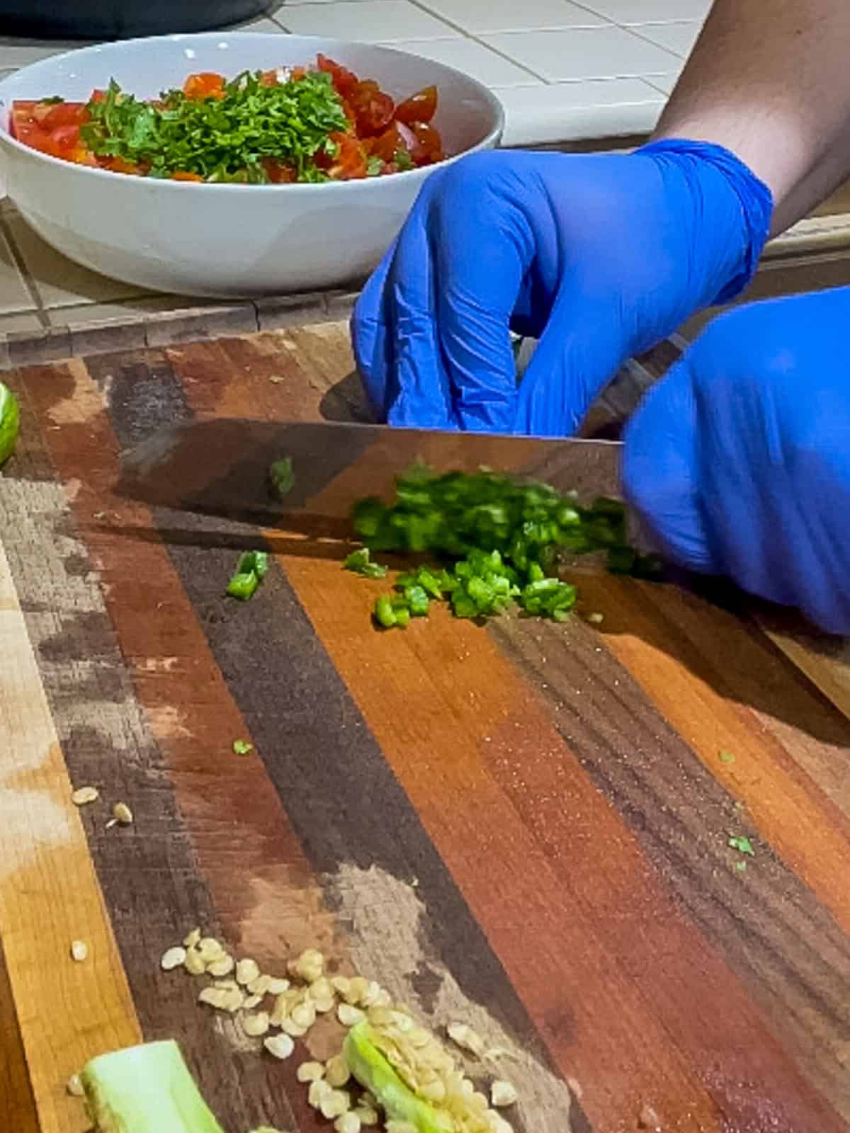 Deseeding and mincing jalapeño peppers with gloves on to avoid burn