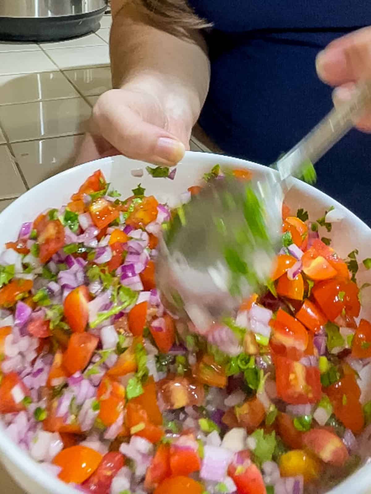 Mixing pico de gallo with a spoon