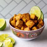 ginger lime tofu cubes in a bowl with lime wedges