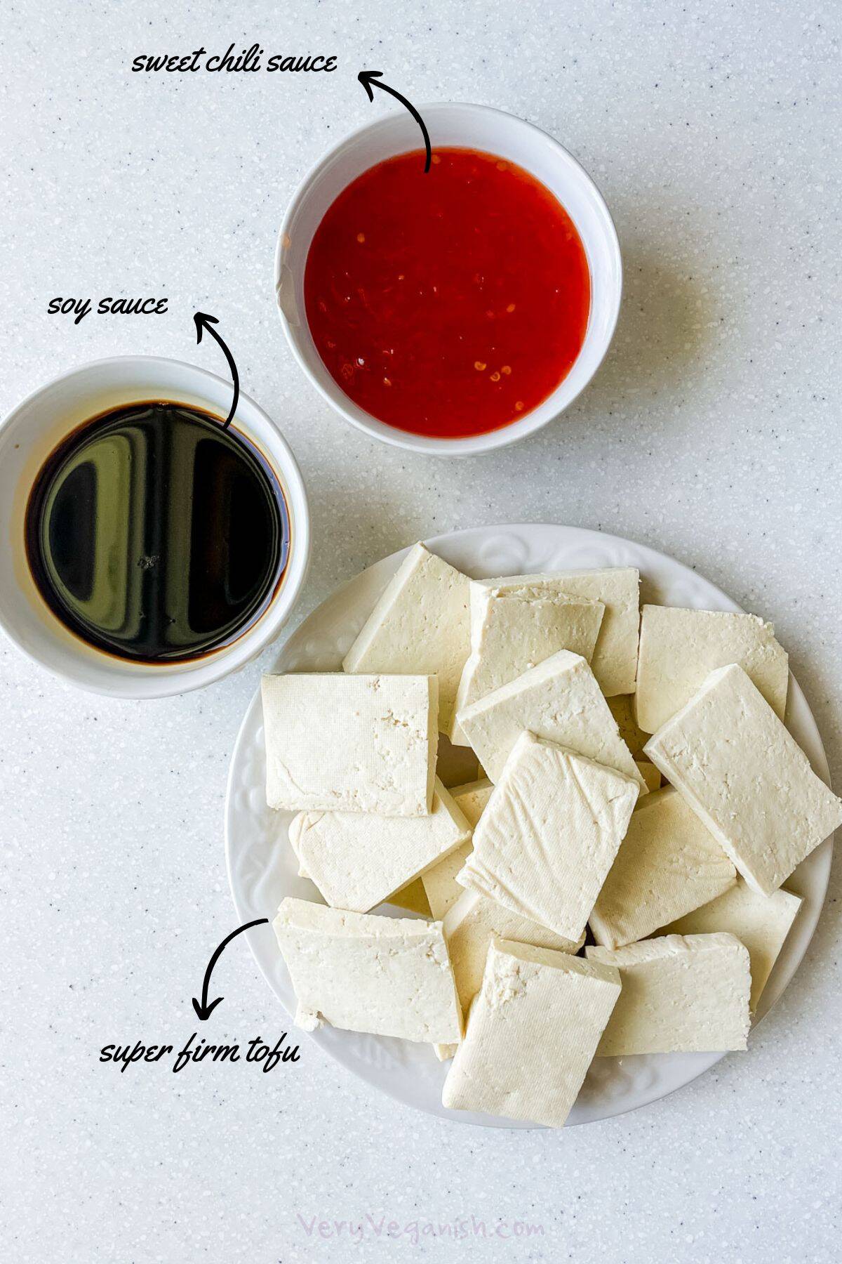 Ingredients on counter for Sweet Chili Air Fryer Tofu Slices: super firm tofu, cut, sweet chili sauce and soy sauce