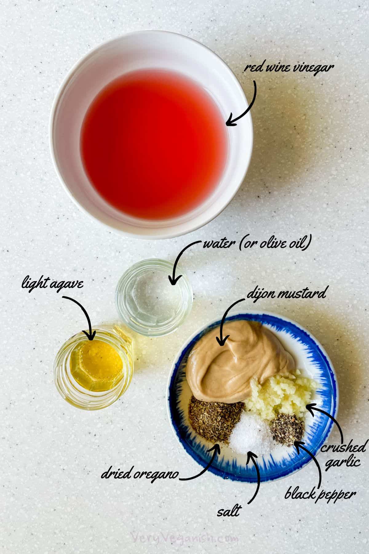 Ingredients for oil-free greek salad dressing: red wine vinegar, water, light agave nectar, dijon mustard, dried oregano, salt, black pepper, crushed garlic