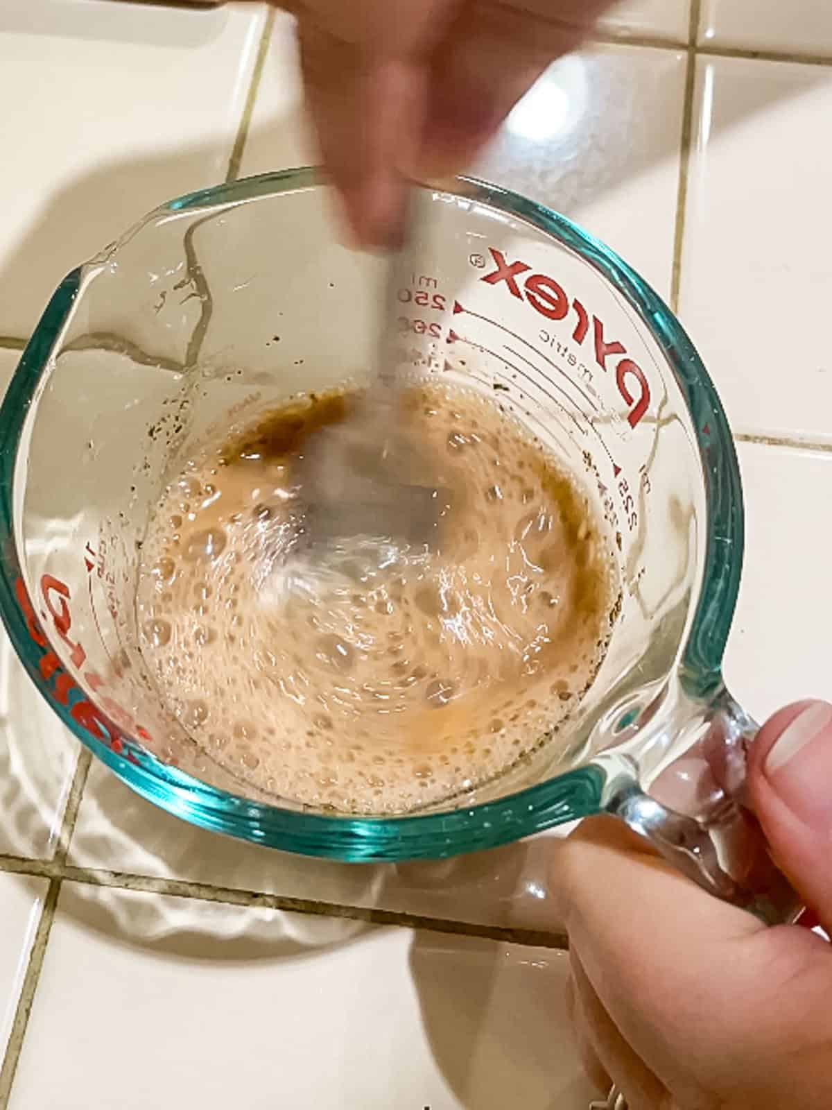 Process Step 2 Whisking dressing in a glass measuring cup with a mini whisk