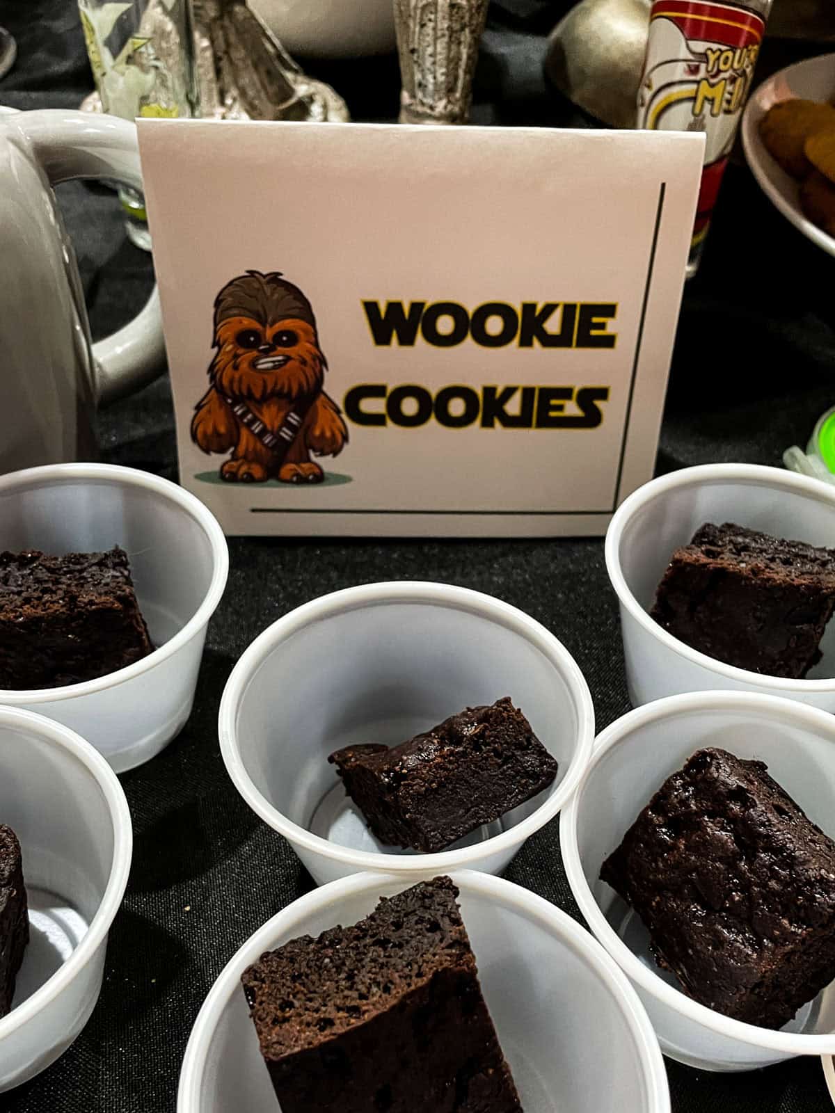 Star wars party table with brownies in cups and a sign that says "wookie cookies"