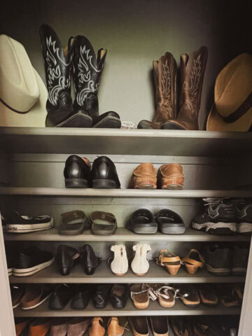 Finished shot of shoe closet filled with shoes with cowboy boots and hats on top shelf