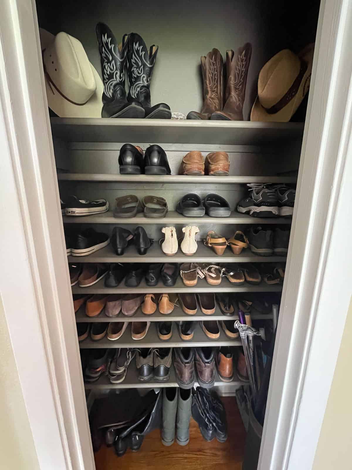 Finished shot of shoe closet filled with shoes with cowboy boots and hats on top shelf