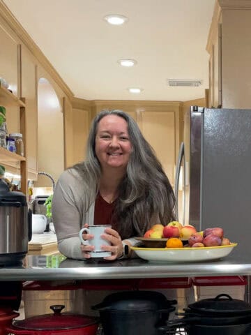 Abi smiling in front of kitchen with newly painted ceiling