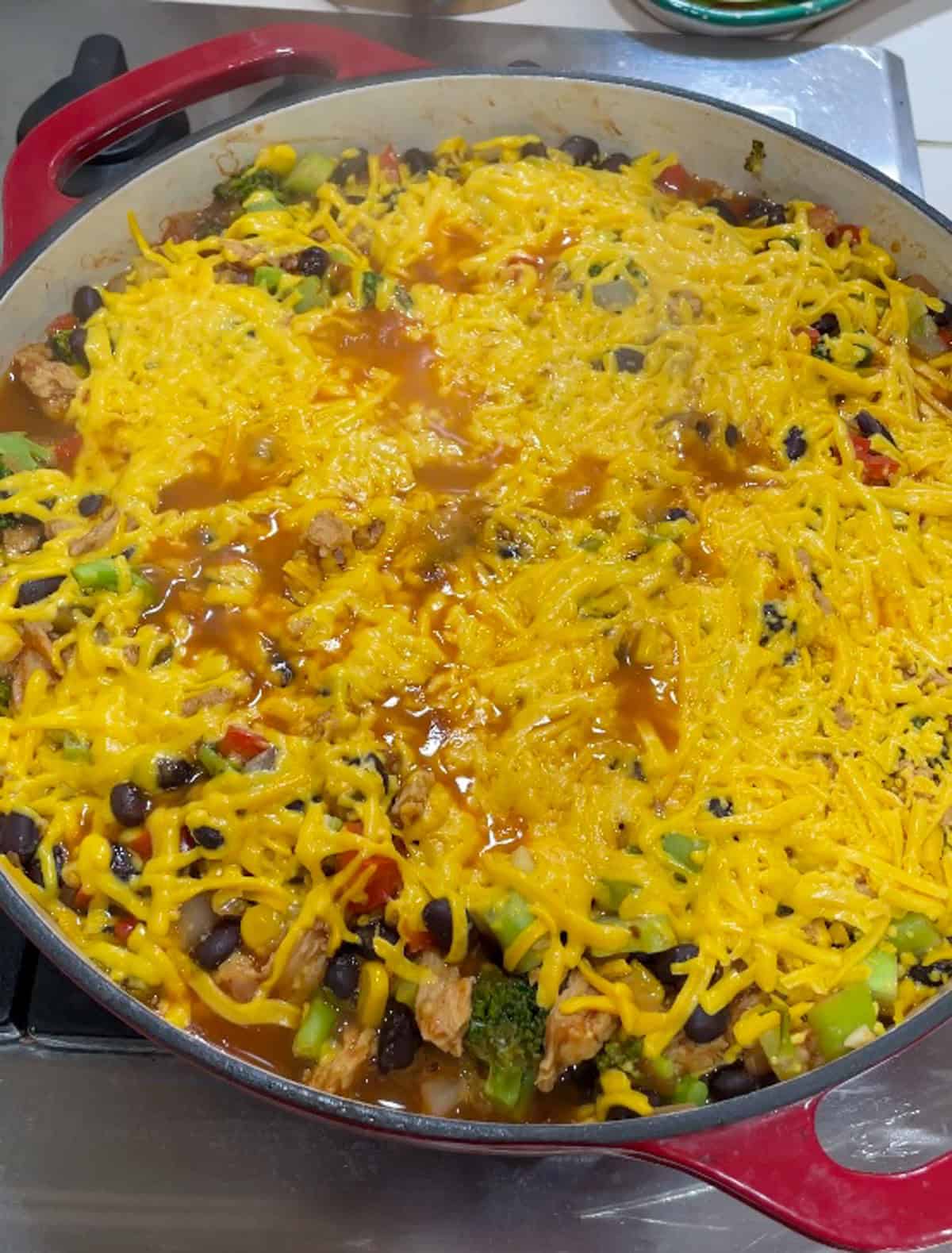 Process photo of step 5 - letting the cheese melt on top of the taco mixture in the skillet on the stove