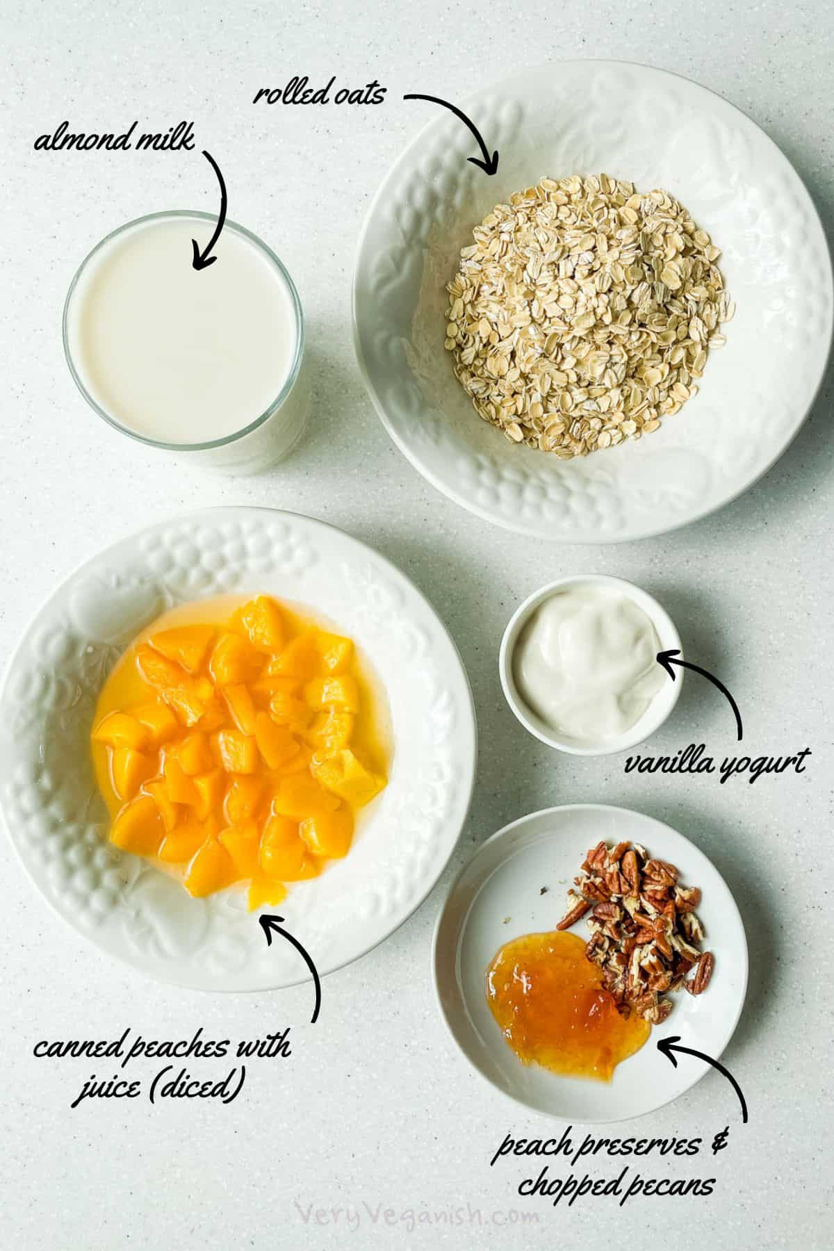 Ingredients for peaches and cream oatmeal: rolled oats, almond milk, canned peaches, vanilla yogurt, peach preserves, chopped pecans