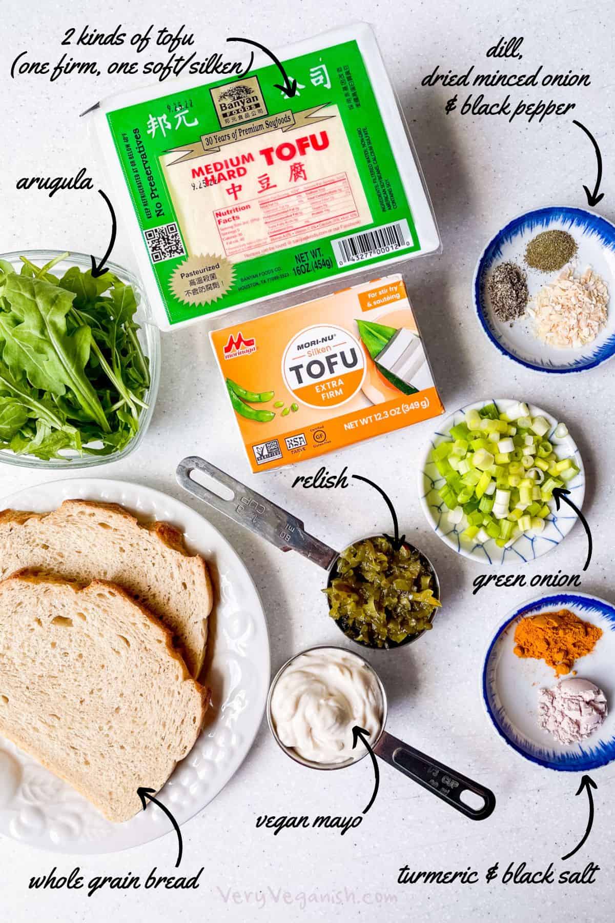 Ingredients for no-cook tofu egg salad sandwich: 2 kinds of tofu (one firm and one soft or silken), vegan mayo, relish, dill, dried minced onion, black pepper, green onion, turmeric, black salt, whole grain bread and arugula