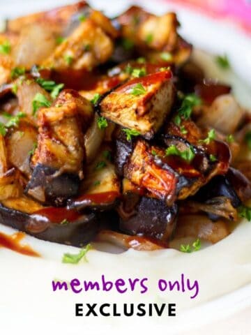 plate with roasted BBQ eggplant and onion on a bed of mashed potatoes with BBQ sauce drizzled on top - label reads "members only exclusive"