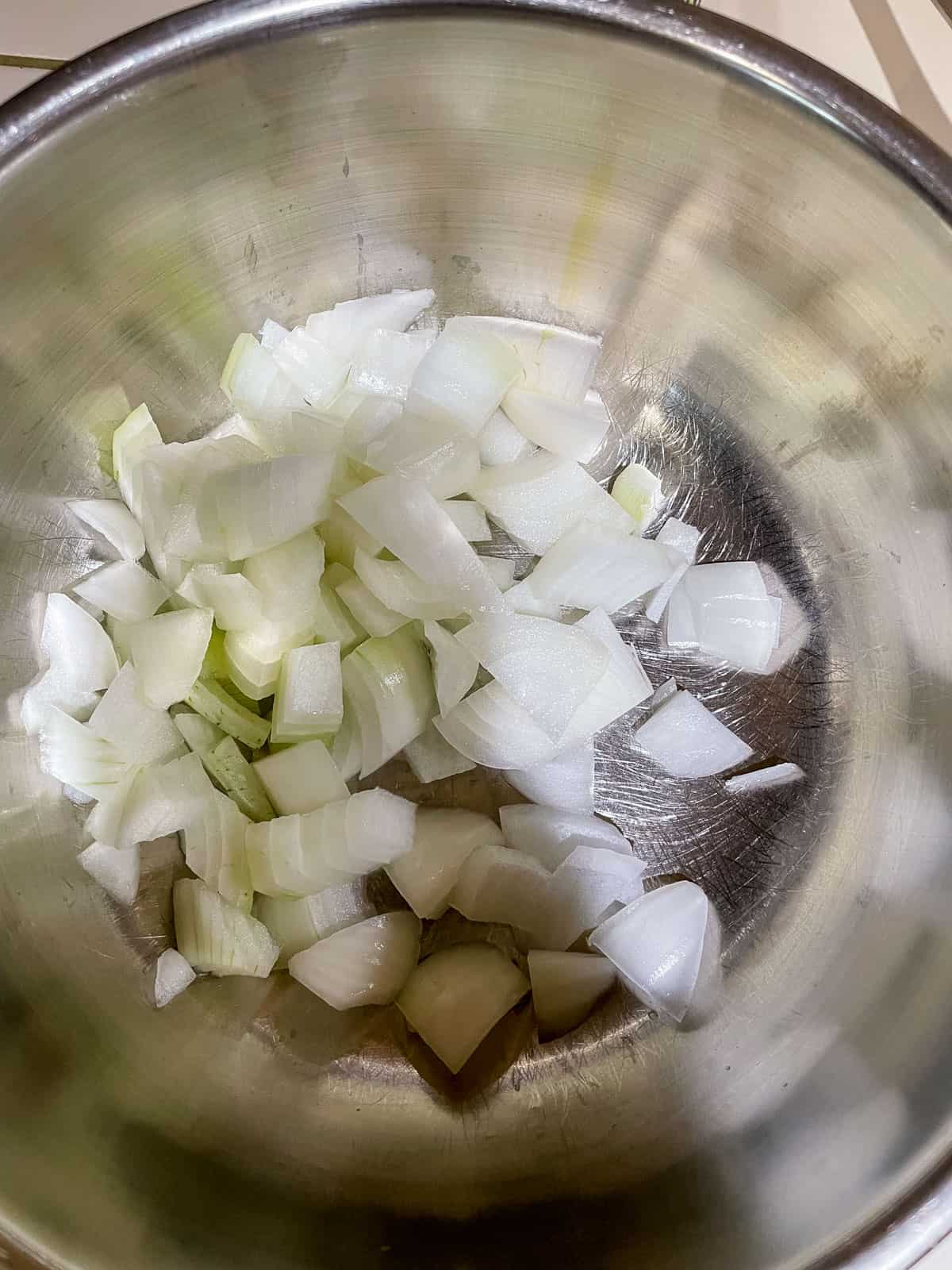 stainless steel mixing bowl with chopped onions