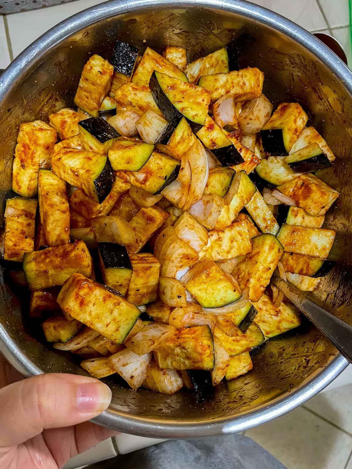 mixing bowl with onions, eggplant, spices and bbq sauce all mixed together