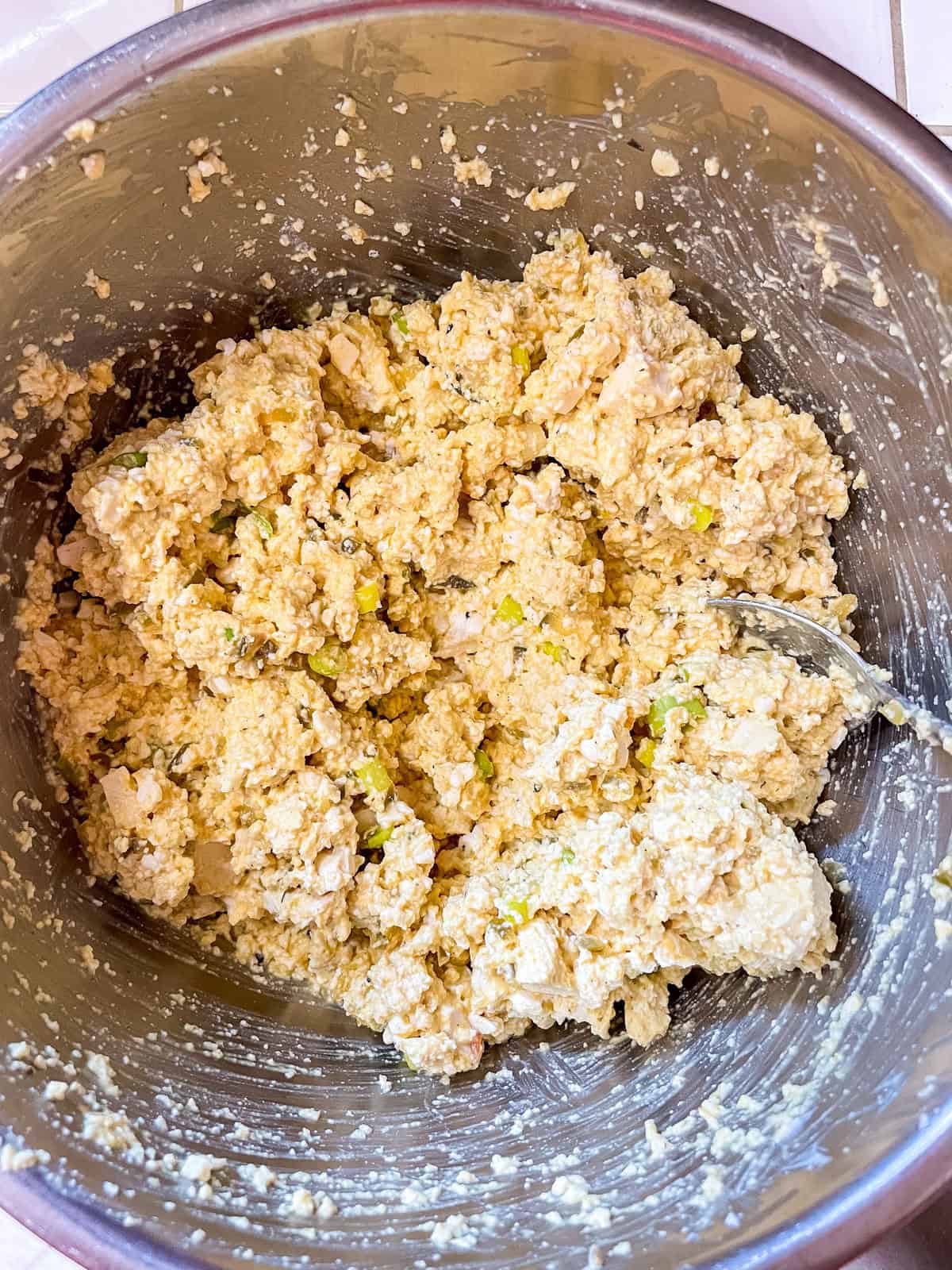 Everything mixed up for tofu egg salad in bowl with spoon
