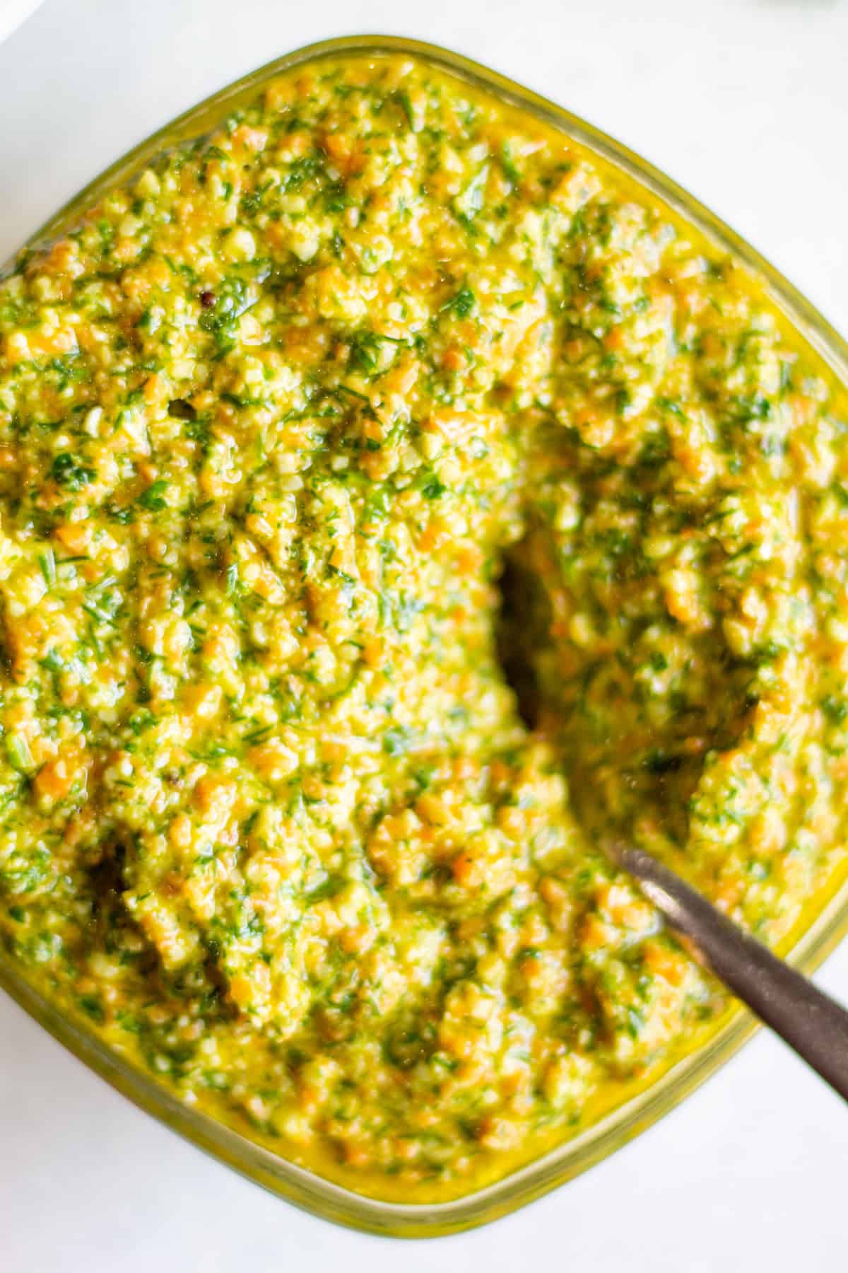 bowl of dill parsley pesto with a spoon nestled inside