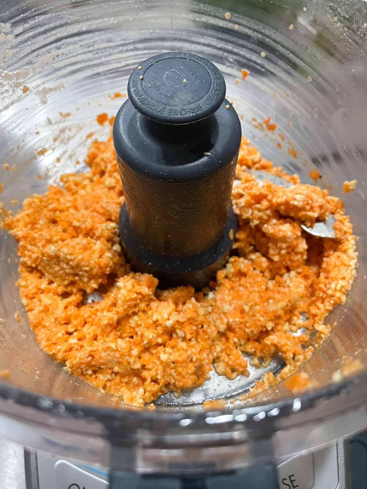 food processor with ground carrot and cashew inside
