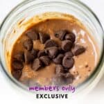Close-up of vegan double chocolate overnight oats in a glass jar topped with dairy-free chocolate chips.