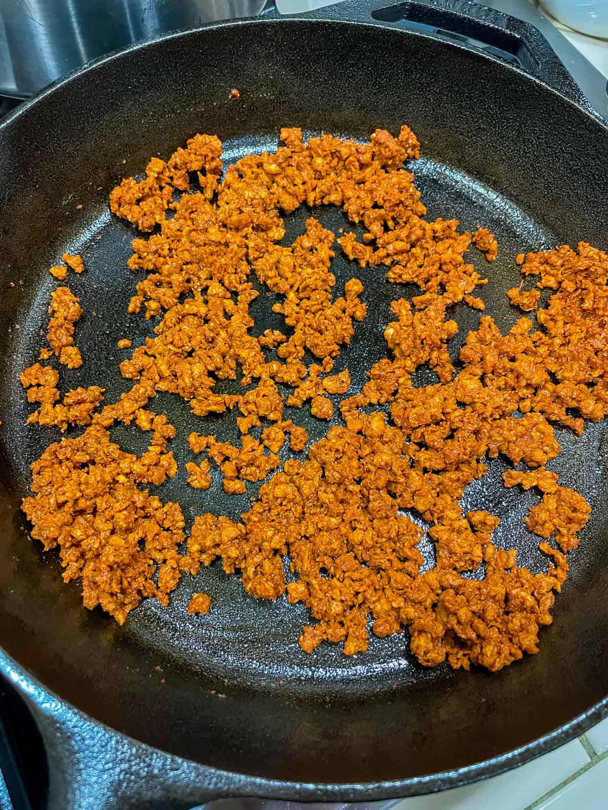 Cooking soy chorizo in a cast iron skillet for vegan Jack in the Box tacos copycat recipe.