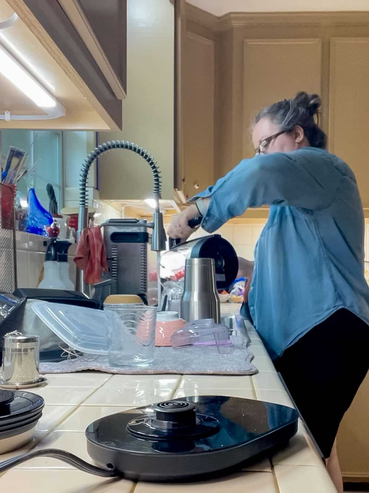 Rinsing an electric kettle with clean water after descaling with white vinegar to remove any remaining residue.