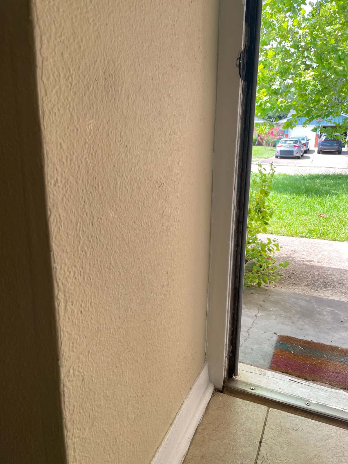 Close-up of an entryway wall near the front door painted with James Alexander Natural Paint, showing the finish and texture after one year.