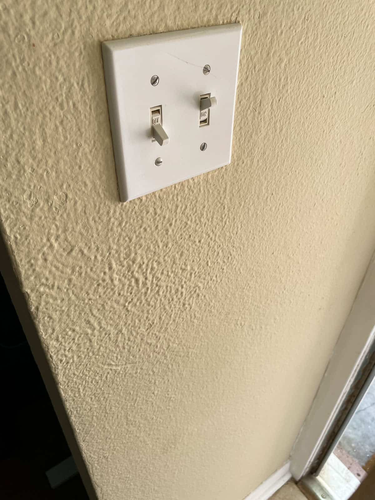Close-up of a double light switch on an interior wall painted with James Alexander Natural Paint, showing how the finish has held up after one year.