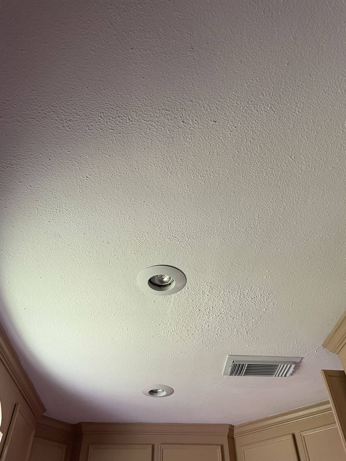 Textured ceiling painted with James Alexander Natural Paint, showing the smooth finish around recessed lights and HVAC vent after one year.