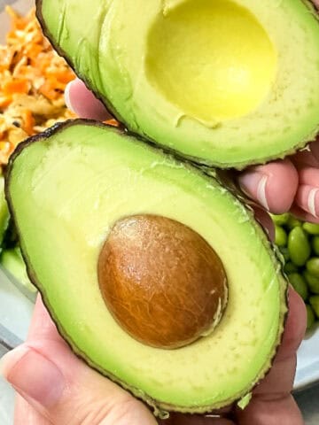 Perfect ripe avocado cut in half showing creamy green flesh and pit, demonstrating an avocado storage hack that keeps avocados fresh for weeks.
