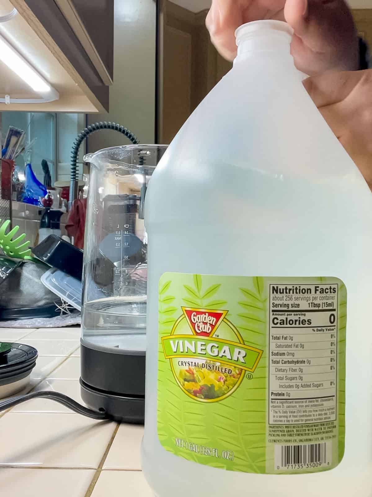 Bottle of distilled white vinegar used to clean and descale an electric kettle naturally without harsh chemicals.