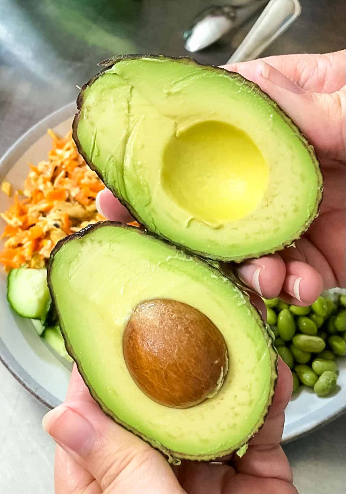 Perfectly ripe avocado cut in half with smooth creamy flesh after being stored in the refrigerator for extended freshness.